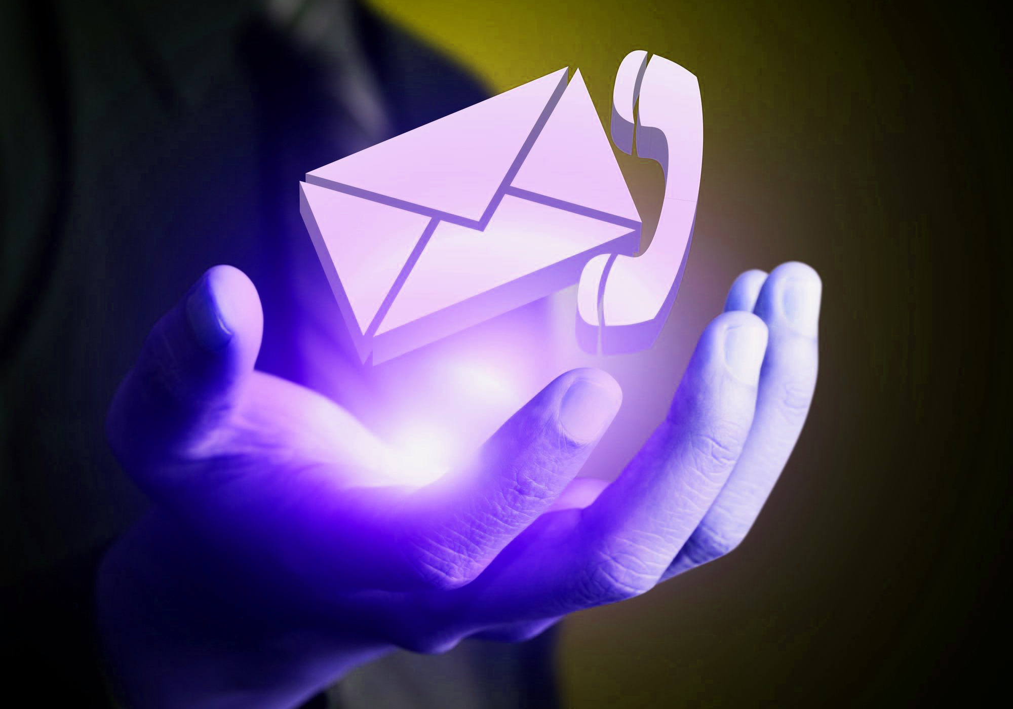Glowing phone and email icons in a man's hand